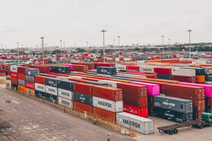 Contêineres coloridos empilhados em um movimentado porto de cargas.