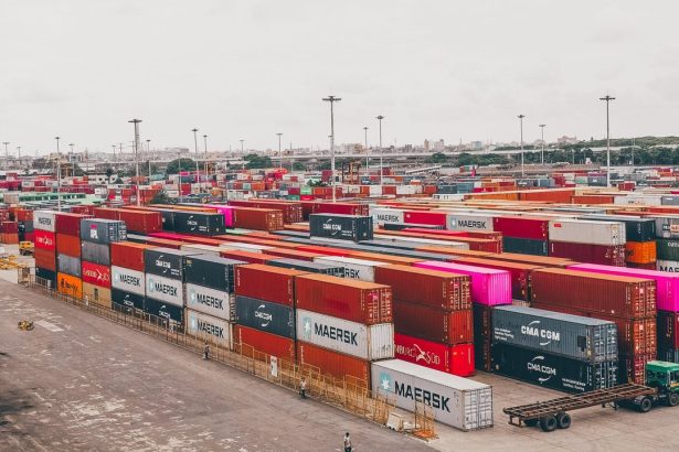 Contêineres coloridos empilhados em um movimentado porto de cargas.