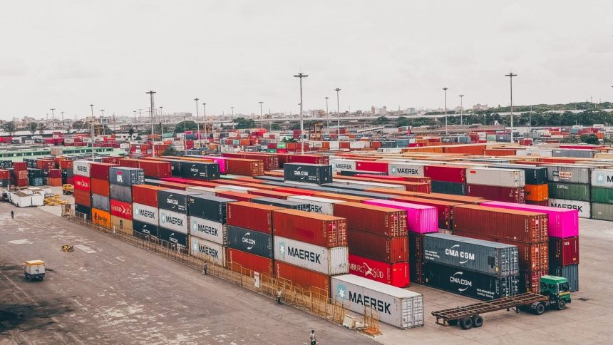 Contêineres coloridos empilhados em um movimentado porto de cargas.